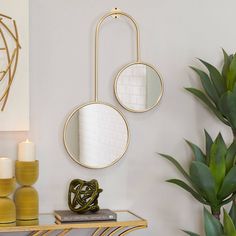 a living room with two round mirrors on the wall and a plant next to it