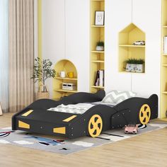 a child's bedroom with yellow and black furniture, bookshelves and shelves