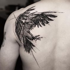 the back of a man's shoulder with a bird tattoo on it