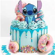 a birthday cake decorated with sprinkles, frosting and an image of stitch