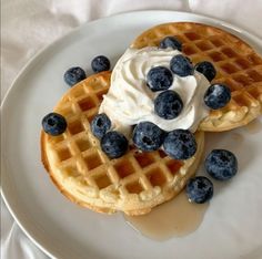 two waffles topped with whipped cream and blueberries