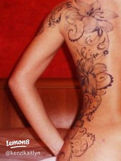 the back of a woman's body with tattoos on it