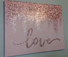 the word love is written in glitter on a pink background