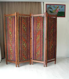 This gorgeous colorful bohemian upholstered wooden room divider would look great anywhere in your living room, office or bedroom. It is entirely made of solid cherry wood and is made in the 1920s or 1930s. PLEASE CONTACT US WITH YOUR LOCATION FOR AN EXACT SHIPPING QUOTE! It has been entirely sanded, stained and oiled. The original fabric was beyond redemption so we replaced it with vintage kilim. Making it a bold, rich, and statement piece of furniture. It would look great in the middle of a roo Room Divider Inspiration, 1920s Room, Fabric Room Divider, Wooden Divider, Room Divider Shelves, Hippie House, Screen Divider, Geometric Furniture, Fabric Room Dividers