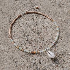 Originally founded as an arts colony, Laguna Beach is a mix of chill beach town and funky bohemian culture, offering some of the clearest blue water and the most relaxing days Southern California has to offer. MATERIALS blue and natural colored Amazonite with cowrie shell and natural wood on a 15" wire, finished with a 1.5" sterling silver extender chain with a ring clasp and tulip shell. Every stone is unique, which means that each bracelet is too. You can expect your jewelry to be one of a kin Beaded Cowrie Shell Jewelry, Jewelry Beach, Beachy Necklaces, Handmade Shell Beaded Necklaces, Ocean-inspired, Beach Necklace, Hippie Jewelry Diy, Ocean-inspired Colorful Beaded Shell Necklaces, Casual Beaded Shell Necklace, Adjustable, Turquoise Shell Beaded Necklaces, Ocean-inspired