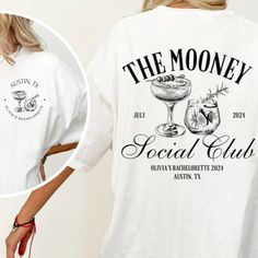 a woman wearing a t - shirt that says the money social club with two glasses on it