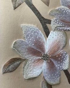 a close up of a flower on a pillow with beadwork and sequins