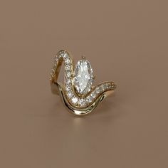 a gold ring with an oval shaped diamond in the center and two smaller diamonds on each side