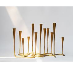 a group of gold candles sitting next to each other on top of a white table