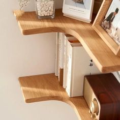 a corner shelf with books and pictures on it