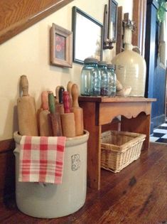 a kitchen area with wooden floors and pictures on the wall, including utensils in a bucket