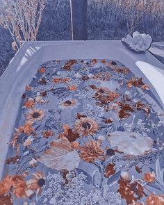 an old bathtub covered in flowers and leaves