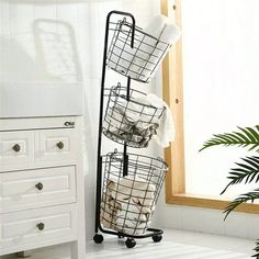 three baskets are stacked on top of each other in front of a mirror and sink