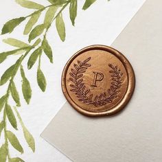 a wax stamp with the letter p on it sitting next to a piece of paper