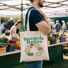 a man carrying a bag that says recycle reuse at an outdoor market