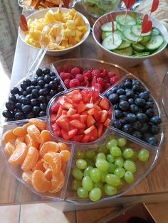 a platter filled with fruit on top of a wooden table