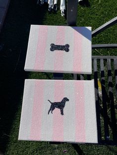 two pink and white striped rugs with black dog stickers on them sitting in the grass