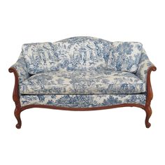 a blue and white couch sitting on top of a wooden frame