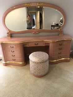 an antique vanity with mirror and stool in a room that has carpet on the floor