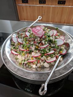 a plate with radishes, onions and other vegetables in it on top of a stove