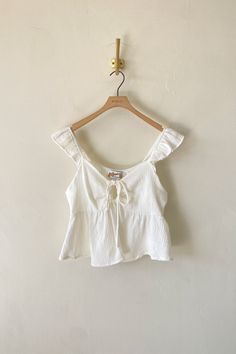 Product Details 100% Cotton Hand Wash Cold Plunging V Neckline w/ Tie Textured Material Keyhole Cutout Peplum Hem Cute Flowy Tops, Cute Simple Tops, Sewn Tops, White Babydoll Top, Cutesy Outfit, Babydoll Tops, Cute White Tops, Preppy Tops, Baby Doll Top