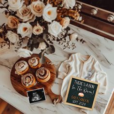 there is a wooden plate with donuts on it next to a bouquet of flowers