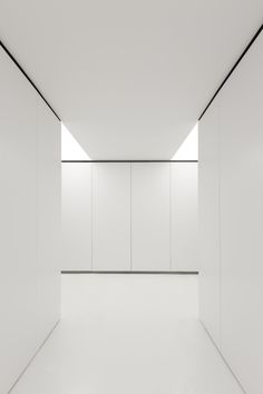 an empty room with white walls and floor