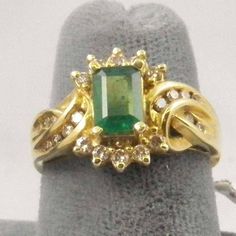 Art Deco Columbian Emerald and Diamond Ring - The main Columbian Emerald gemstone is of a rectangular cut measuring 7.8 mm x 5.5 mm and weighing approximately 1.03 carats. It is of good color and medium clarity. There are 10 round brilliant cut channel set diamonds weighing a total of 0.37 carats and 12 round brilliant cut channel set diamonds weighing a total of O.31 carats. The 14k yellow gold ring weighs a total of 4.68 grams and is size 6 3/4. It come with an appraisal for insurance replacem Art Deco Rectangular Emerald Ring For Anniversary, Vintage Green Cluster Ring For Formal Occasions, Art Deco Rectangular Emerald Anniversary Ring, Vintage Emerald Cut Diamond Emerald Ring, Vintage Emerald Cut Cluster Ring With Center Stone, Vintage Emerald Cut Emerald Ring With Diamond Accents, Vintage Emerald Cut Gemstone Cluster Ring, Vintage Emerald Cut Cluster Ring With Gemstone, Classic Green Rectangular Diamond Ring