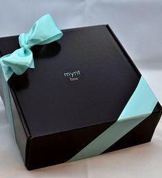 a black and blue gift box with a bow on the top that says nym