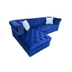 a large blue couch with two pillows on it's back and an ottoman in the middle