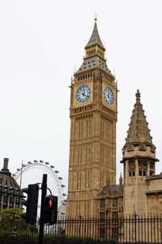 the big ben clock tower towering over the city of london with ferris wheel in background