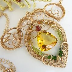 "The lemon quartz at the center of this necklace is bright, reminiscent of a midday sun. It isn't strictly a lemon quartz: there are little hints of orange to it. It glows rather magnificently. An exquisite frame of 14k gold fill wire has been constructed aroun the stone with complex swirls. A layer of chrome diopside, peridot, and tourmaline wraps around the inside and some madeira citrine accents the top of the stone. The pendant is about 2.5\" long by 3\" wide and the double layer chain is ad Yellow Sapphire Jewelry With Gemstone Accents, Yellow Sapphire Jewelry With Gemstone Accents For Gift, Green Citrine Jewelry Gift, Green Citrine Jewelry For Gifts, Citrine Gemstone Jewelry For May Birthstone, Fine Green Citrine Jewelry, Elegant Citrine Wire Wrapped Jewelry, Spiritual Yellow Jewelry With Birthstone, Citrine Jewelry With Gemstone Accents For Jewelry Making