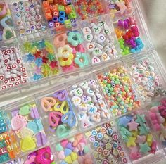 two plastic bins filled with lots of different types of beads and letters on top of each other