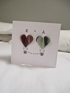 two hot air balloons in the shape of hearts on a card