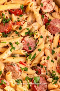 pasta with sausage, tomatoes and parsley in a pan