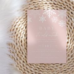 a pink and white snowflaked baby shower is on top of a wicker basket