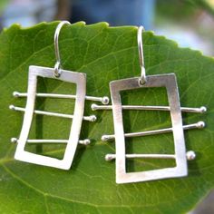 My ladder earrings are entirely hand fabricated and formed from sterling silver, and hang on hand bent silver ear wires.  They're whimsical,unique, modern, and chic.  These are all made to order and OOAK, the pair you receive my vary slightly from the image.please note-the earrings I'm wearing to showcase size-are my personal pair. Artsy Nickel-free Sterling Silver Earrings, Unique Sterling Silver Wrap Earrings, Unique Sterling Silver Pierced Wrap Earrings, Modern Handmade Wrap Earrings, Modern Wire Wrapped Earrings, Modern Handmade Dangle Wrap Earrings, Artsy Silver Pierced Earrings, Modern Handmade Wrap Earrings For Everyday, Artsy Sterling Silver Dangle Earrings