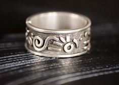 This is a wide chunky silver ring in a single copy. The image is abstract and inspired, without being tied to a specific style, here you can find something from Indians and Scythians at the same time, something from my head, an abstraction. the ring is suitable for both men and women, as well as many works from our collection. The width of the ring is 0.39 inches. Why should you buy a jewelry in my shop? -free woldwide shipping -high-quality - unique author's design -the uniqueness and individuality that you will feel wearing our jewelry -love in every product Order procrssing usually takes 1-3 business How to order: 1.select jewelry. 2. click ADD TO CART. For multiple items go back to the listing and repeat the steps. If you have a problem with your order, please contact us before leaving Silver Jewelry With Thick Band And Ring Detail, Silver Jewelry With Thick Band, Hand Forged Wide Band Sterling Silver Ring, Sterling Silver Jewelry With Thick Band, Unique Thick Band Jewelry Gift, Symbolic Hand Forged Ring Jewelry, Sterling Silver Wide Band Promise Ring, Silver Hand Forged Wide Band Open Ring, Hand Forged Silver Ring With Thick Band