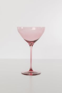 a pink wine glass sitting on top of a table