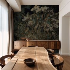 a wooden table with two bowls on it in front of a large painting behind it