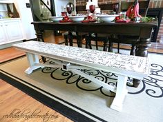 a white bench sitting on top of a hard wood floor next to a kitchen counter