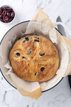 a loaf of bread with raisins in it on a white marble counter top