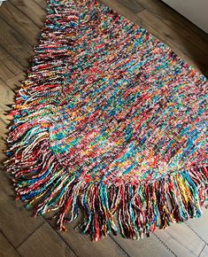 a multicolored rug with fringes on the floor in a living room or bedroom