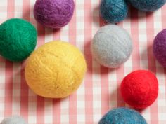 several balls of wool on a checkered tablecloth with one ball in the middle