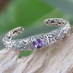 Featuring an amethyst stone with deep purple hues, this cuff bracelet is charming and delightful. Indonesian artisan Kadek Hendra handcrafts the bracelet from sterling silver, depicting majestic dragonflies against frangipani trees and flowers. The gemstone weighs 2 carats. Sacred Garden, Blue Topaz Bracelet, Silver Jewelry Design, Blue Topaz Stone, Blue Topaz Earrings, Sterling Silver Cuff Bracelet, Topaz Earrings, Bracelet Cuff, Amethyst Bracelet