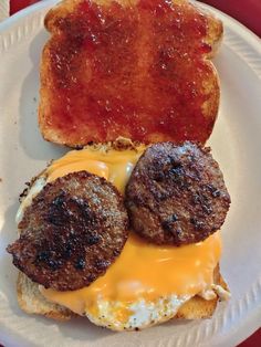 an egg and cheese breakfast sandwich on a white paper plate with toasted buns