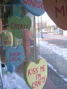 several hearts hanging from the side of a store window