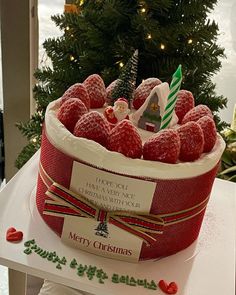 a christmas cake with raspberries in it on a table next to a tree