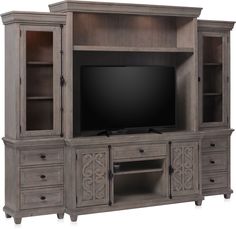 a large entertainment center with drawers and a flat screen tv