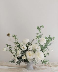 a vase filled with white flowers on top of a table